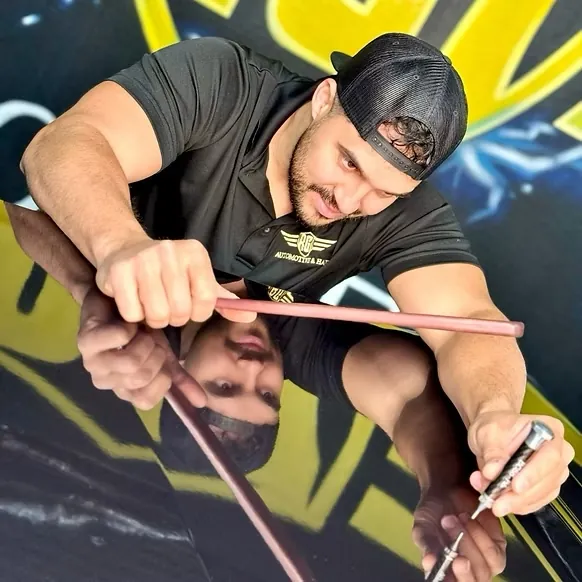 RG7 technician using a PDR rod on a mirror-finish car panel